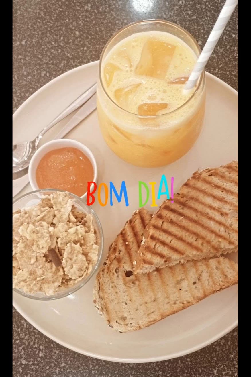 Tosta mista, sumo natural e um copo de granola.